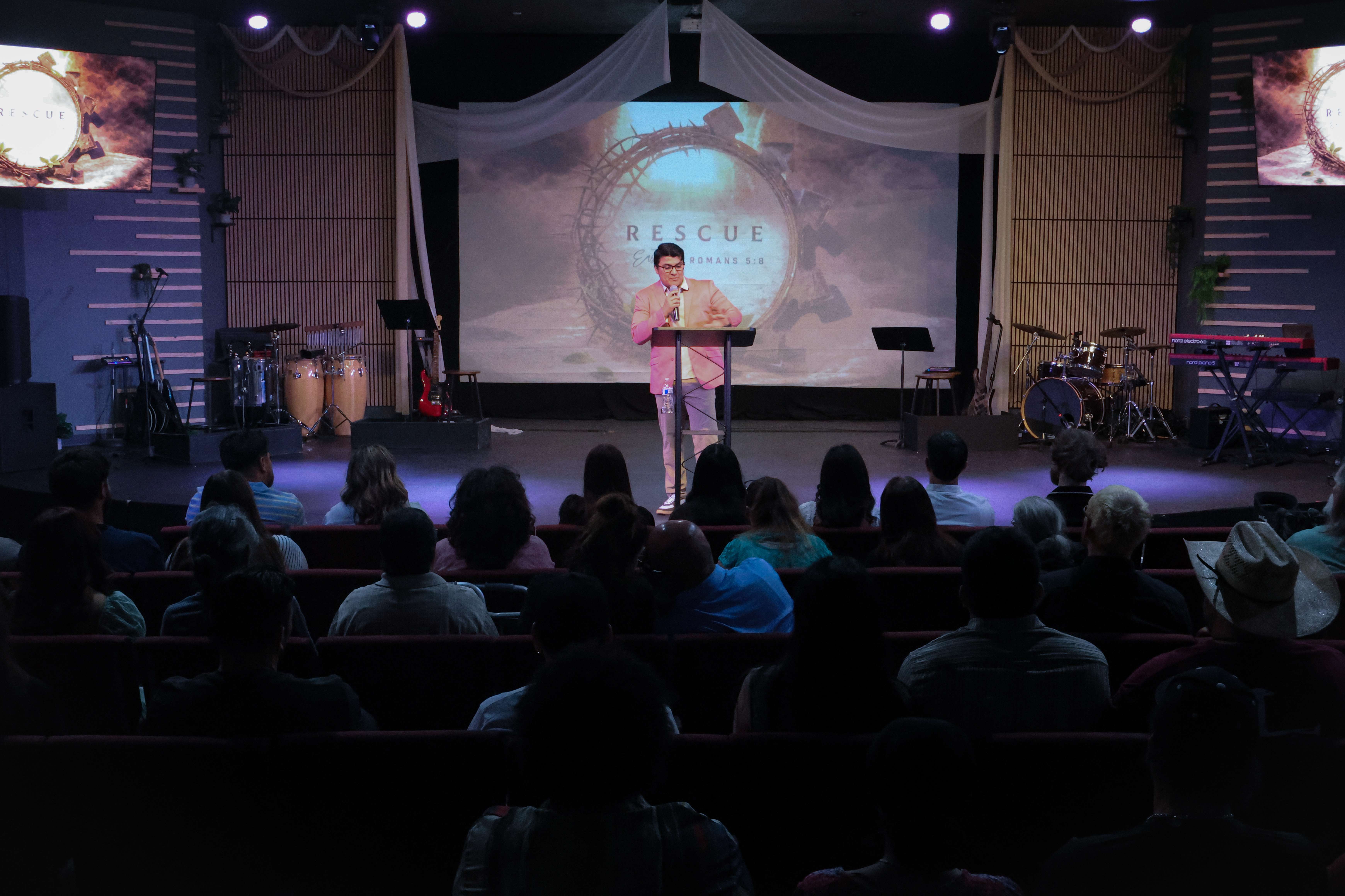 Pastor preaching at Ethos Church with Rescue series on screen