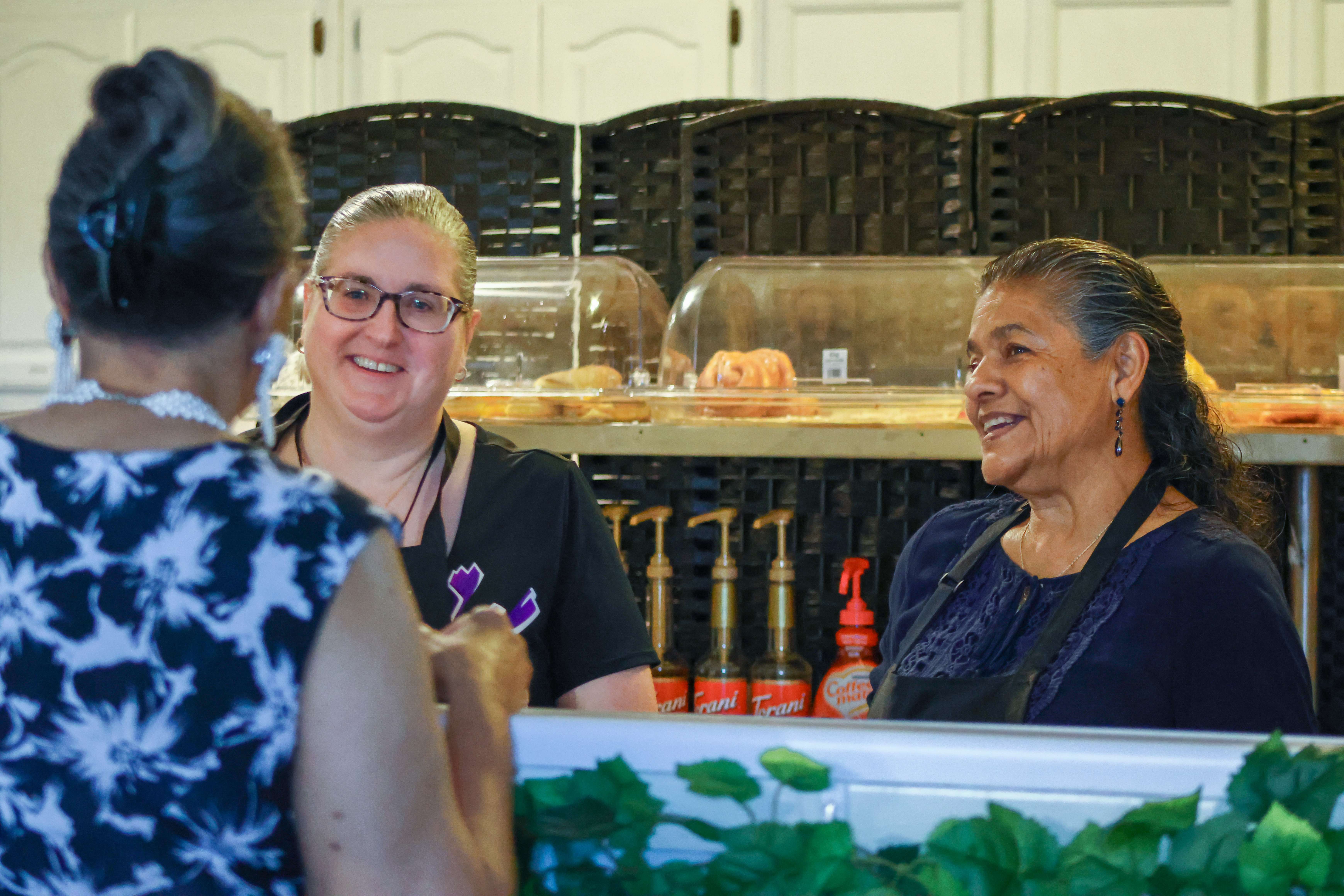 Volunteers serving at the Ethos Church café, smiling and welcoming a guest